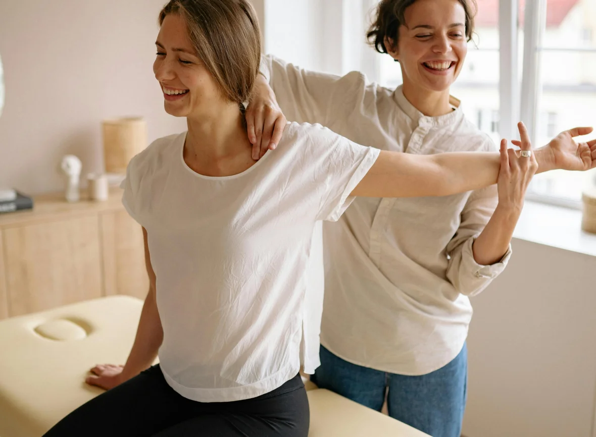 A practitioner checking a patient's shoulder mobility in a bright clinic